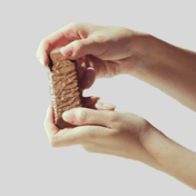 Två händer som bryter en bar för att visa  hur god den