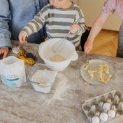 Mamma och barn bakar med järnrik barnmat med hemjärnspulver i ett kök