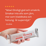 Hand håller fram en Feméa hemjärnsbar och ett stort citat över bilden från en nöjd kund som säger att baren är otroligt god och smakrik och att den inte alls smakar som järn utan som kladdkaka och houng och är supernöjd. Fem stjärnor